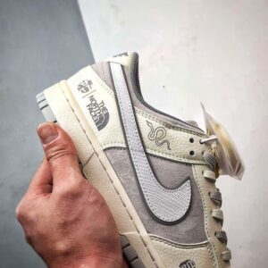 【AT3271】Nike x The North Faceのコラボレーションモデル、グレーと白の組み合わせのローカットシューズ、Nike Dunk Low RetroとThe North Faceのサイン入り。シューズは、ホワイトとグレーの配色で、北面のシンボルがデザインされています。パッと目を引くスタイリッシュなランニングシューズです。