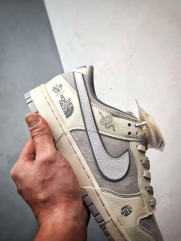 【AT3271】Nike x The North Faceのコラボレーションモデル、グレーと白の組み合わせのローカットシューズ、Nike Dunk Low RetroとThe North Faceのサイン入り。シューズは、ホワイトとグレーの配色で、北面のシンボルがデザインされています。パッと目を引くスタイリッシュなランニングシューズです。