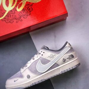 【AT3271】Nike x The North Faceのコラボレーションモデル、グレーと白の組み合わせのローカットシューズ、Nike Dunk Low RetroとThe North Faceのサイン入り。シューズは、ホワイトとグレーの配色で、北面のシンボルがデザインされています。パッと目を引くスタイリッシュなランニングシューズです。