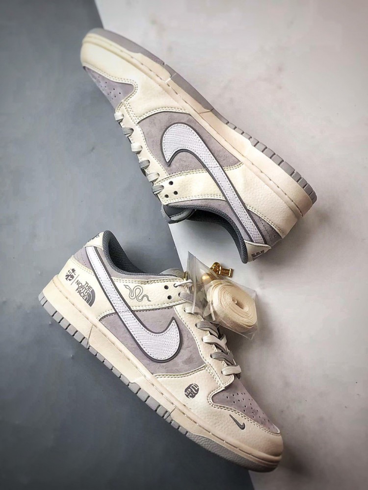 【AT3271】Nike x The North Faceのコラボレーションモデル、グレーと白の組み合わせのローカットシューズ、Nike Dunk Low RetroとThe North Faceのサイン入り。シューズは、ホワイトとグレーの配色で、北面のシンボルがデザインされています。パッと目を引くスタイリッシュなランニングシューズです。