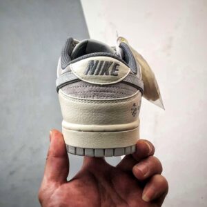 【AT3271】Nike x The North Faceのコラボレーションモデル、グレーと白の組み合わせのローカットシューズ、Nike Dunk Low RetroとThe North Faceのサイン入り。シューズは、ホワイトとグレーの配色で、北面のシンボルがデザインされています。パッと目を引くスタイリッシュなランニングシューズです。