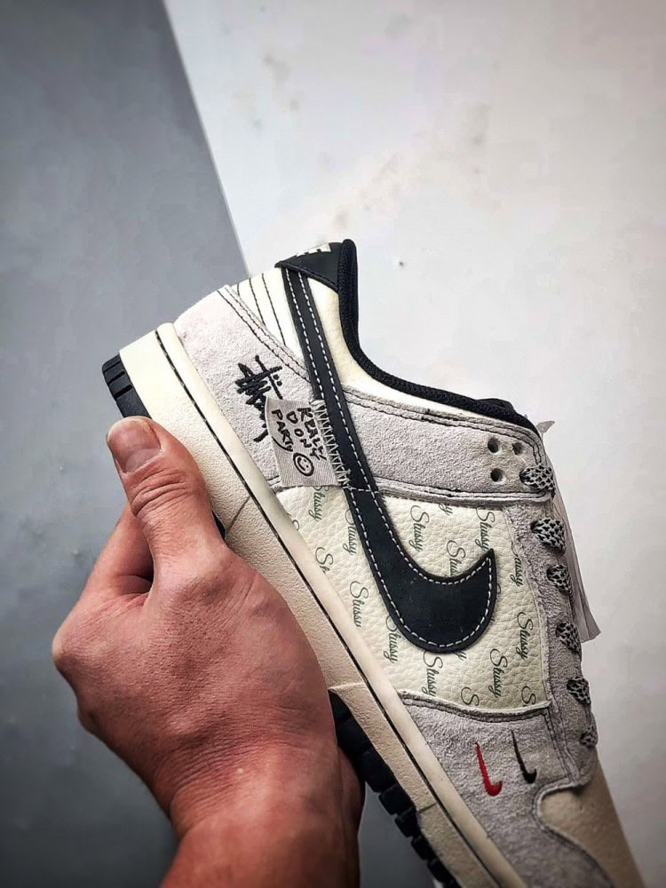 【AT3299】Nike Dunk x Stussyのコラボレーションクラシックスニーカー、Nike Dunk Low Retroが登場しました。Stussyの布製タグが付いたベージュと黒の低カットカジュアルスポーツシューズ。