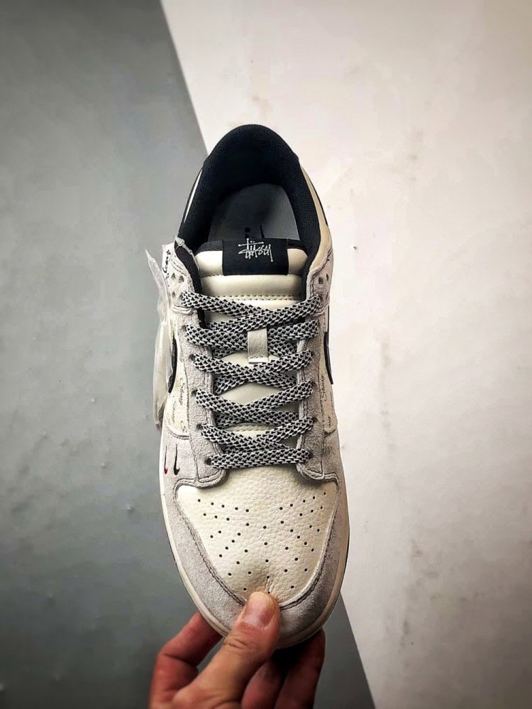 【AT3299】Nike Dunk x Stussyのコラボレーションクラシックスニーカー、Nike Dunk Low Retroが登場しました。Stussyの布製タグが付いたベージュと黒の低カットカジュアルスポーツシューズ。