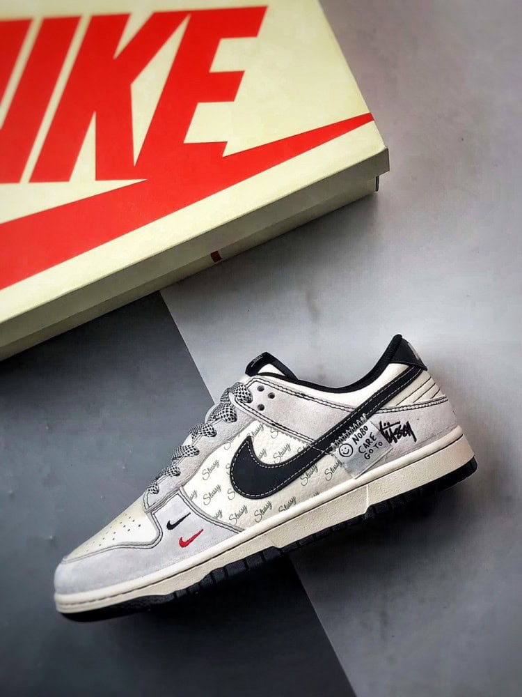 【AT3299】Nike Dunk x Stussyのコラボレーションクラシックスニーカー、Nike Dunk Low Retroが登場しました。Stussyの布製タグが付いたベージュと黒の低カットカジュアルスポーツシューズ。