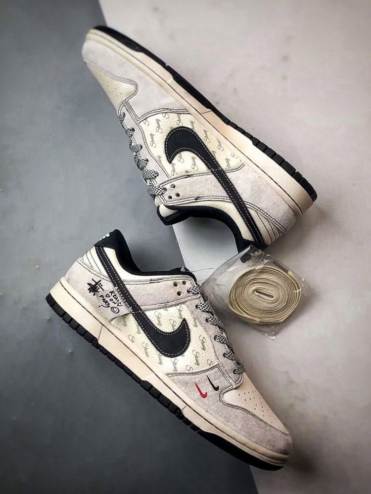 【AT3299】Nike Dunk x Stussyのコラボレーションクラシックスニーカー、Nike Dunk Low Retroが登場しました。Stussyの布製タグが付いたベージュと黒の低カットカジュアルスポーツシューズ。