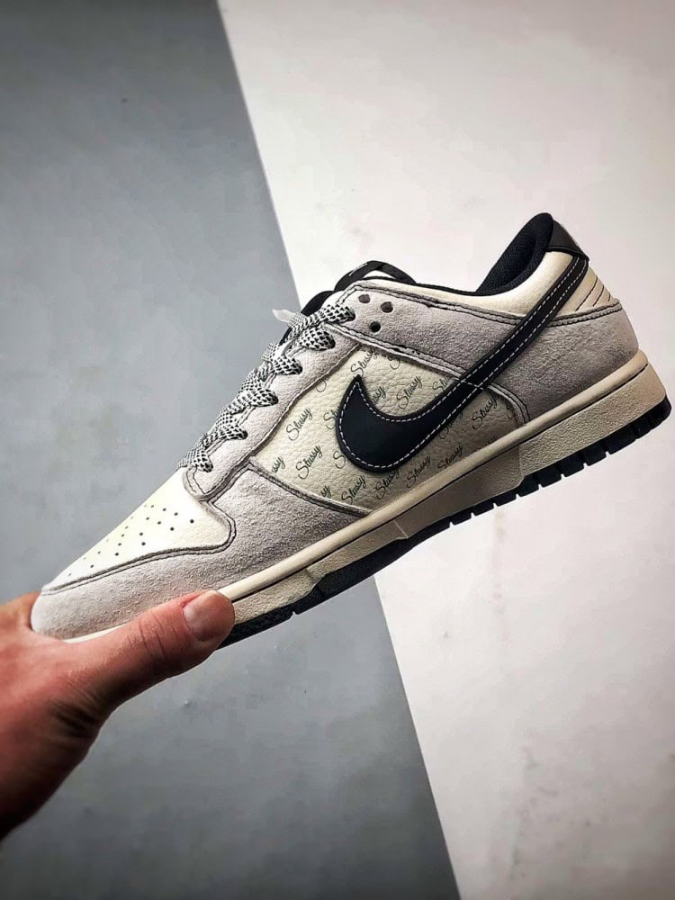 【AT3299】Nike Dunk x Stussyのコラボレーションクラシックスニーカー、Nike Dunk Low Retroが登場しました。Stussyの布製タグが付いたベージュと黒の低カットカジュアルスポーツシューズ。