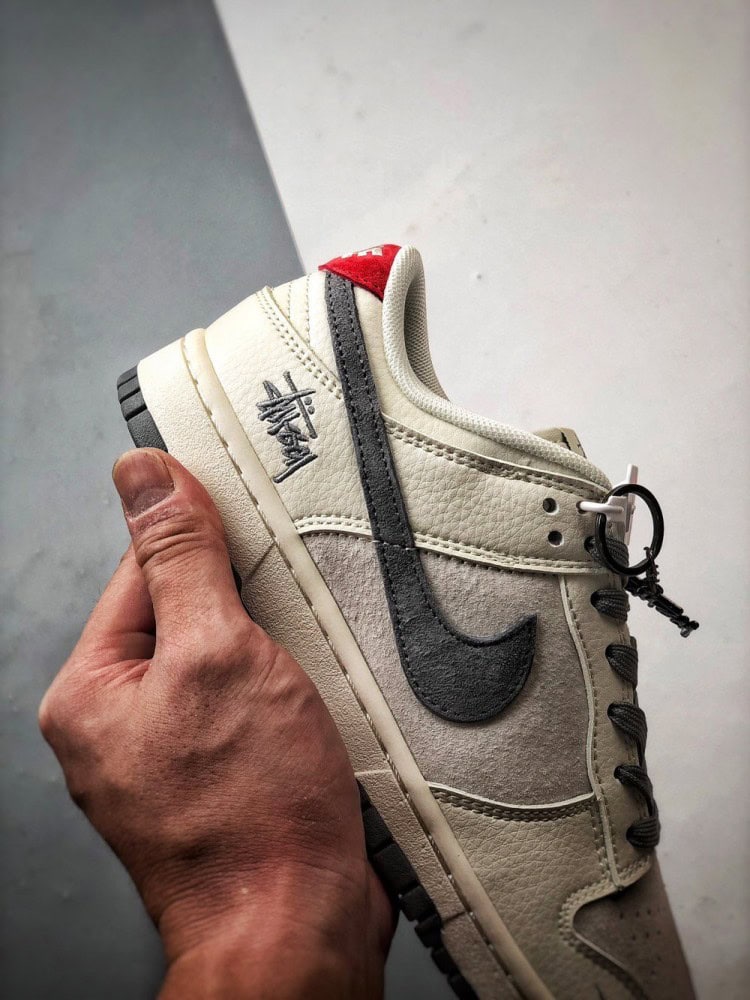 【AT3330】Nike x Stussy Dunk コラボレーションモデル、Nike Dunk Low Retro。ステューシーのグレーと赤いテールが印象的なローカットスポーツシューズ。