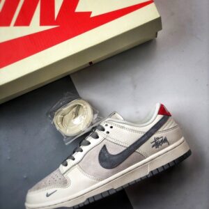 【AT3330】Nike x Stussy Dunk コラボレーションモデル、Nike Dunk Low Retro。ステューシーのグレーと赤いテールが印象的なローカットスポーツシューズ。