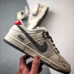 【AT3330】Nike x Stussy Dunk コラボレーションモデル、Nike Dunk Low Retro。ステューシーのグレーと赤いテールが印象的なローカットスポーツシューズ。