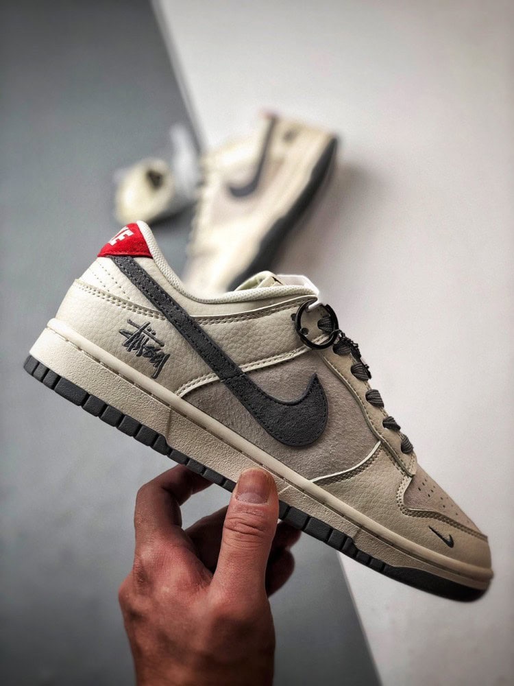 【AT3330】Nike x Stussy Dunk コラボレーションモデル、Nike Dunk Low Retro。ステューシーのグレーと赤いテールが印象的なローカットスポーツシューズ。